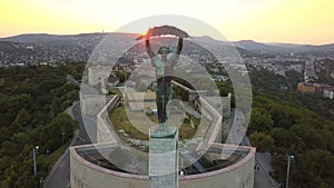 Budapest, Hungary - 4K flying towards the Statue of Liberty on Gellert Hill at sunset with Buda Hills