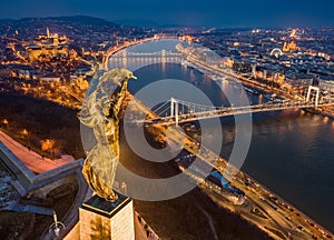 Budapest, Hungary - Aerial blue hour view of illuminated Statue of Liberty with Elisabeth Bridge, Buda Castle Royal Palace