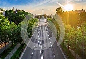 Budapest, Hungary - Aerial drone view of totally empty Andrassy street at sunrise with green trees and sunlight and Heroes` Square