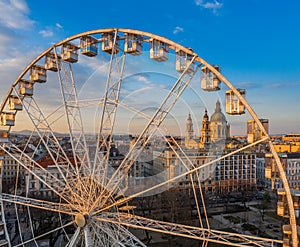 Budapest, Hungary - Aerial view of the ferris wheel at Elisabeth Square Erzsebet ter at sunset with St. Stephen`s Basilica