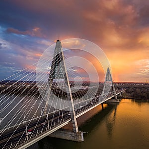 Budapest, Hungary - Aerial view of Megyeri Bridge over River Danube with beautiful golden sky and clouds and heavy traffic