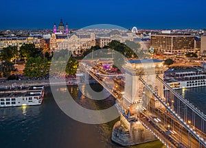 Budapest, Hungary - Aerial view of Szechenyi Chain Bridge with St. Stephen`s Basilica, ferris wheel and cruise ships at blue hour