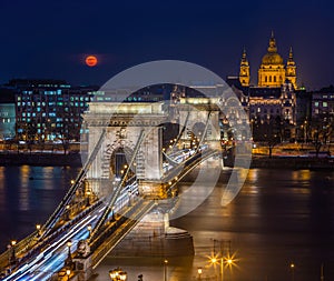 Budapest, Hungary - Blood Moon rising over downtown of Budapest with beautiful Szechenyi Chain Bridge and St. Stephen`s Basilica