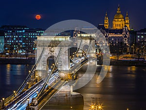 Budapest, Hungary - Blood Moon rising over downtown of Budapest with beautiful Szechenyi Chain Bridge and St. Stephen`s Basilica