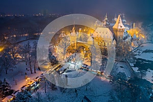 Budapest, Hungary - Christmas market in snowy City Park Varosliget from above at night with snowy trees and Vajdahunyad