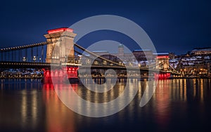 Budapest, Hungary - Illuminated Szechenyi Chain Bridge at dusk on a winter evening with Buda Castle Royal Palace at background