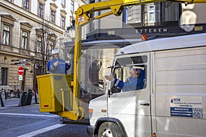 BUDAPEST, HUNGARY - JANUARY, 2017: Worker replacing old bulbs in the lantern street lighting with new ones.