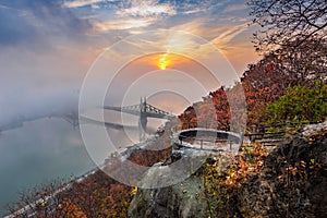 Budapest, Hungary - Lookout on Gellert Hill with Liberty Bridge Szabadsag Hid, fog over River Danube, colorful sky and clouds