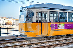 BUDAPEST, HUNGARY - MARCH 30, 2019: Old yellow tram speeds up along city streets. The historical center of the capital of Hungary