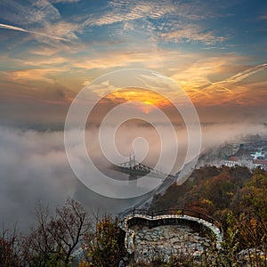 Budapest, Hungary - Mysterious foggy sunrise with Liberty Bridge Szabadsag hid and lookout on Gellert Hill