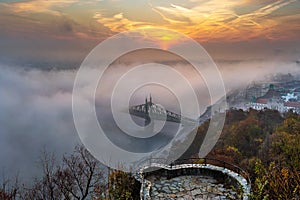 Budapest, Hungary - Mysterious foggy sunrise with Liberty Bridge Szabadsag hid and lookout on Gellert Hill