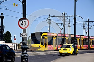 Yellow tram and taxi cab on busy street in Budapest. summer day.
