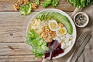 Buddha bowl, balanced food, vegetarian menu. Old wooden dark table, top view, copy space. Eggs, avocado, salad lettuce, bulgur,