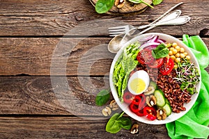 Buddha bowl dish with boiled egg, chickpea, fresh tomato, sweet pepper, cucumber, savoy cabbage, red onion, green sprouts, spinach