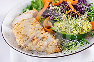 Buddha bowl dish with chicken fillet, avocado, red cabbage, carrot