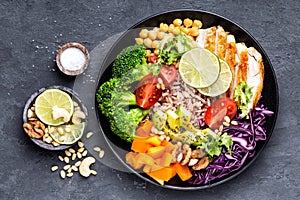 Buddha bowl dish with chicken fillet, brown rice, avocado, pepper, tomato, broccoli, red cabbage, chickpea, fresh lettuce salad, p