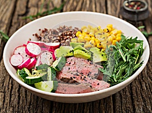Buddha bowl lunch with grilled beef steak and quinoa, corn, avocado, cucumber