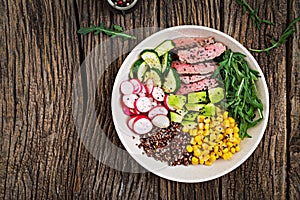 Buddha bowl lunch with grilled beef steak and quinoa, corn, avocado, cucumber