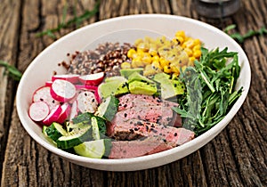 Buddha bowl lunch with grilled beef steak and quinoa, corn, avocado, cucumber