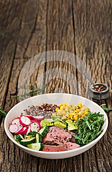 Buddha bowl lunch with grilled beef steak and quinoa, corn, avocado, cucumber