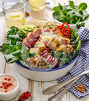 Buddha bowl of mixed vegetables,tofu cheese and groats. Healthy and nutritious vegan meal.