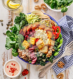 Buddha bowl of mixed vegetables,tofu cheese and groats. Healthy and nutritious vegan meal.