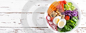 Buddha bowl salad with chickpeas, sweet pepper, tomato, cucumber, red cabbage kale, fresh radish, spinach leaves and boiled egg, h