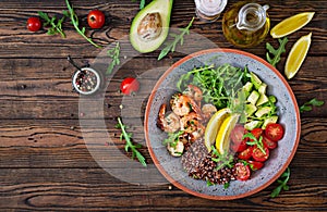 Buddha bowl with shrimps, tomato, avocado, quinoa, lemon and arugula