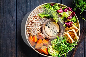 Buddha bowl with tofu, avocado, rice, seedlings, sweet potato and tahini dressing