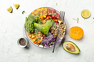 Buddha bowl vegetarian, vegan dish avocado, tomato, red cabbage, chickpea, fresh lettuce salad, pumpkin, persimmon