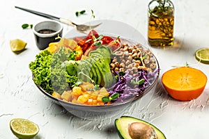 Buddha bowl vegetarian, vegan dish with avocado, tomato, red cabbage, chickpea, fresh lettuce salad, pumpkin, persimmon. Healthy