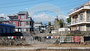 Buddha chowk, Pokhara, Nepal - Washed clothes and blankets on a stone wall in the background of Machapuchare.