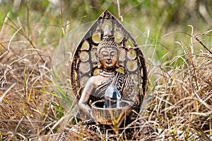 Buddha craft in the grass with a gem