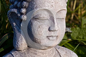 Buddha face on sunny meadow.