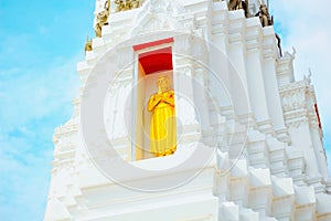 Buddha golden arches on top of a white pagoda and blue sky