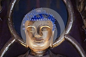 Buddha head with golden face and blue hairs in old Chinese Kofukuji-Temple, Nagasaki, Japan.