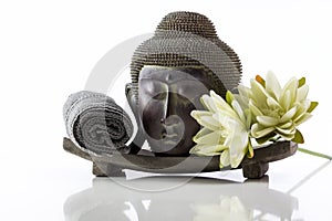 Buddha head on a white background, towel and lotus