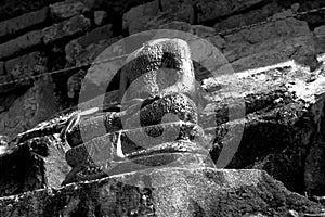 Buddha image with no head ancient and bricks background in black and white theme