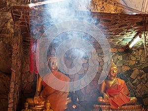 Buddha image statue inside cave with light smoke as travel peaceful place