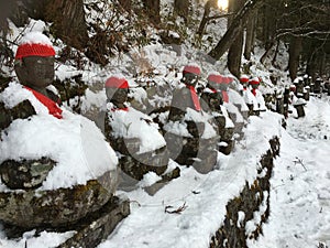 Buddha Narabi Jizo statues with red hats landmark under snow in