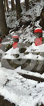 Buddha Narabi Jizo statues with red hats landmark under snow in