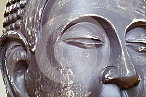 Buddha`s face close-up. The Buddha image in ceramics. The texture of the background and focus of the soft focus.