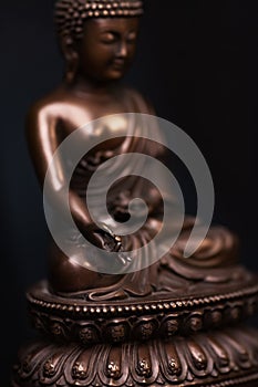 Buddha`s figure, brown color made of metal in a meditation pose