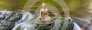 Buddha sculpture sitting in flowing water cascade