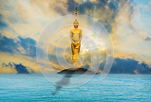 Buddha stands majestically, quietly, there is an evening sky with the sea as the background.