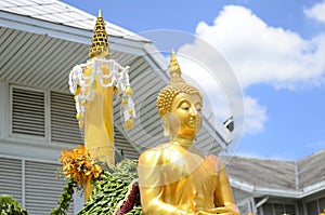 Buddha statue on bright sky background.