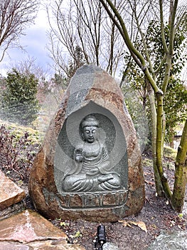 Buddha statue carved in stone. Garden decoration