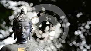 Buddha statue closeup with bokeh light background