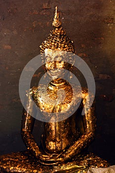 Buddha statue covered with offering of golden leaves wai phra at Wat Yai Chai Mongkhon temple in Ayutthaya, Thailand.