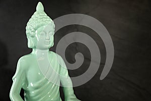 Buddha statue on dark background. Space for text
